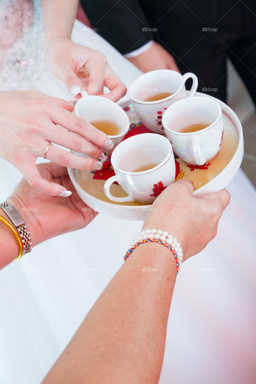 Person's hand holding tray with ea cups