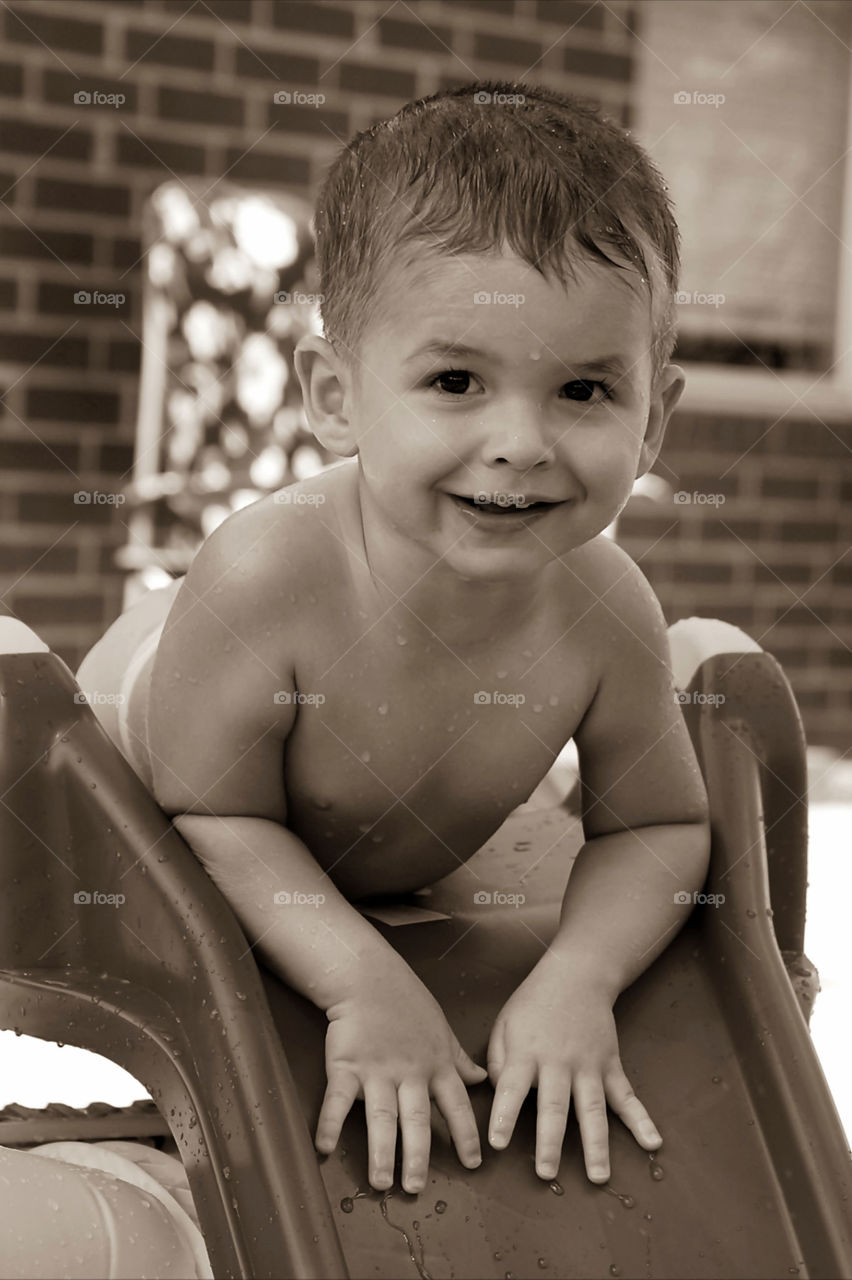 Playing on the slide with water on it in our backyard...