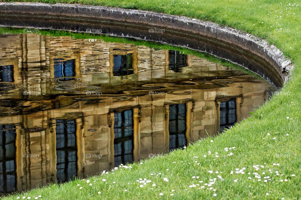 Reflection of a house in the city in a fountain pond