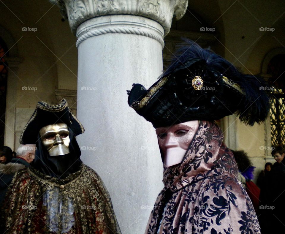 Venetian masks costumes parading in St Mark square in Venice 