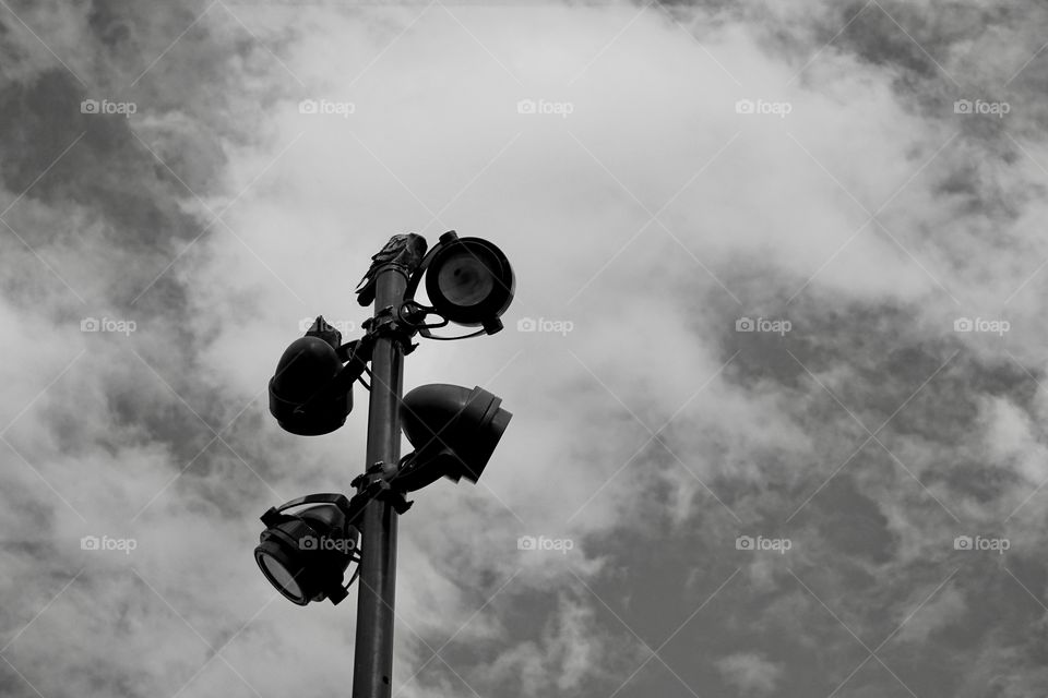 Two pigeons is staying on streetlight. Monochrome image