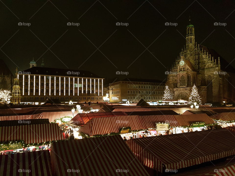 Charming christmas market in foreground with the Frauenkirche church in background in evening. Germany.