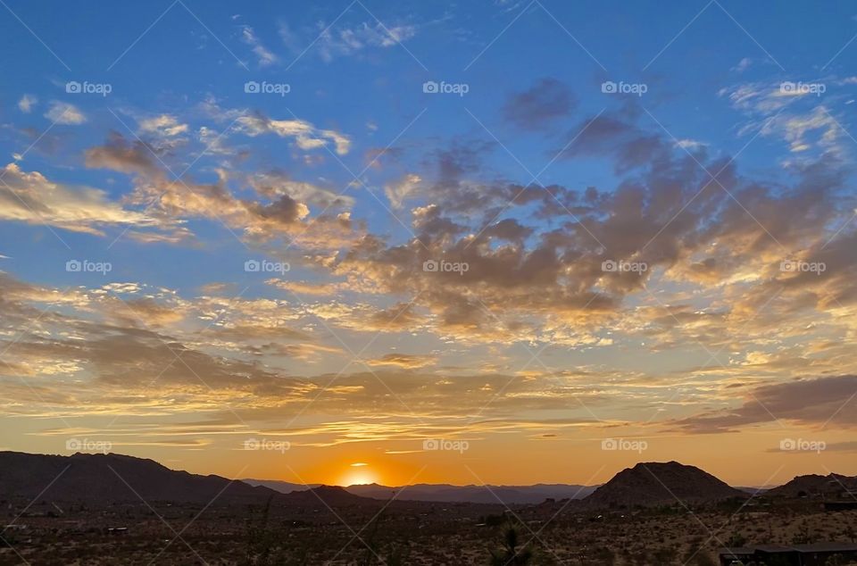 The most beautiful sunset in Joshua Tree California shining all the beautiful sunset colors across the desert.