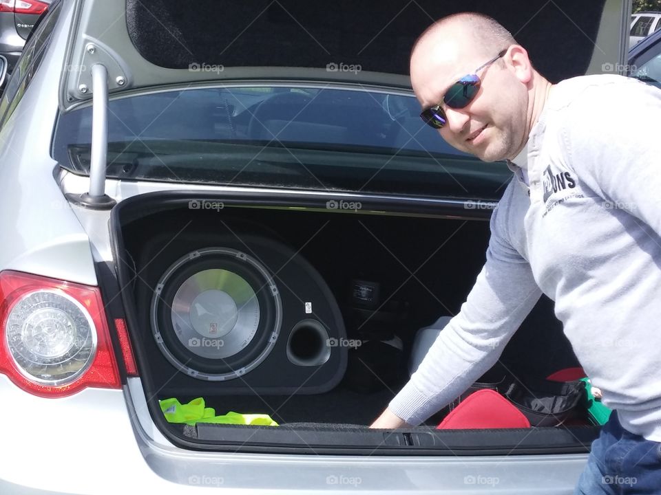 Man unloading belongings from car trunk