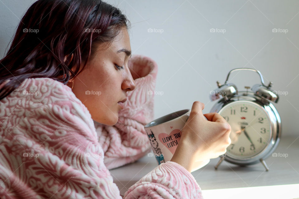 Young sleepy woman with a cup of coffee