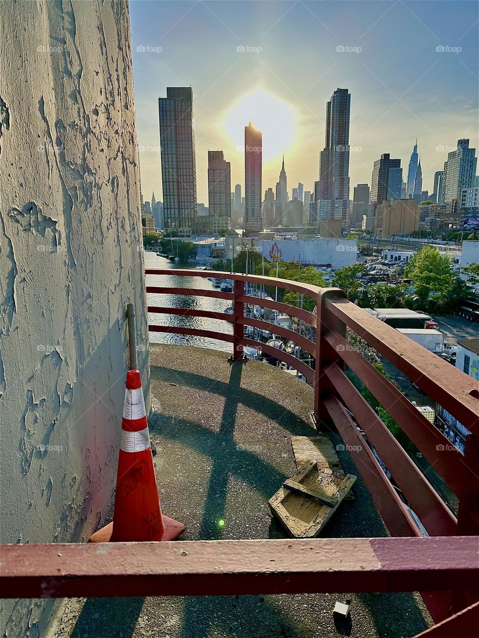 This is “Newtown Creek” seen from the center outpost of the “Pulaski Bridge” that connects LIC, Queens to “Greenpoint”, Bklyn at sunset time. Across the “East River” we see “Manhattan” including the “Empire State Building”. 2024. Hypnotic Productions