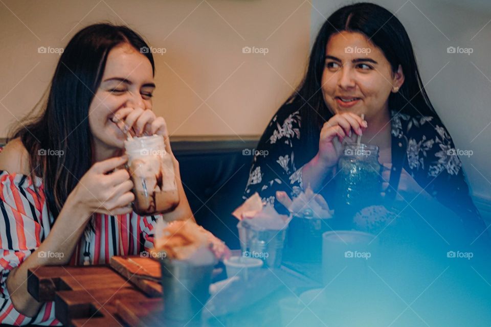 Friend smiling happy to enjoy her company in a cafeteria