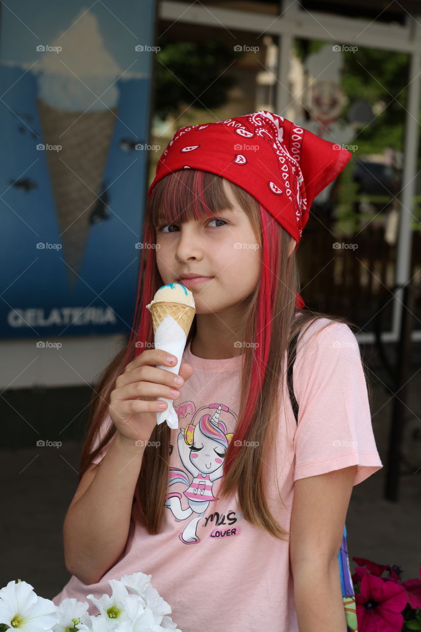 девочка с розовыми волосами в красной бандане есть мороженое