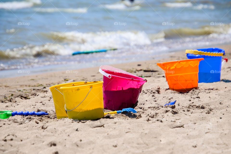 Colorful plastic buckets on a beach