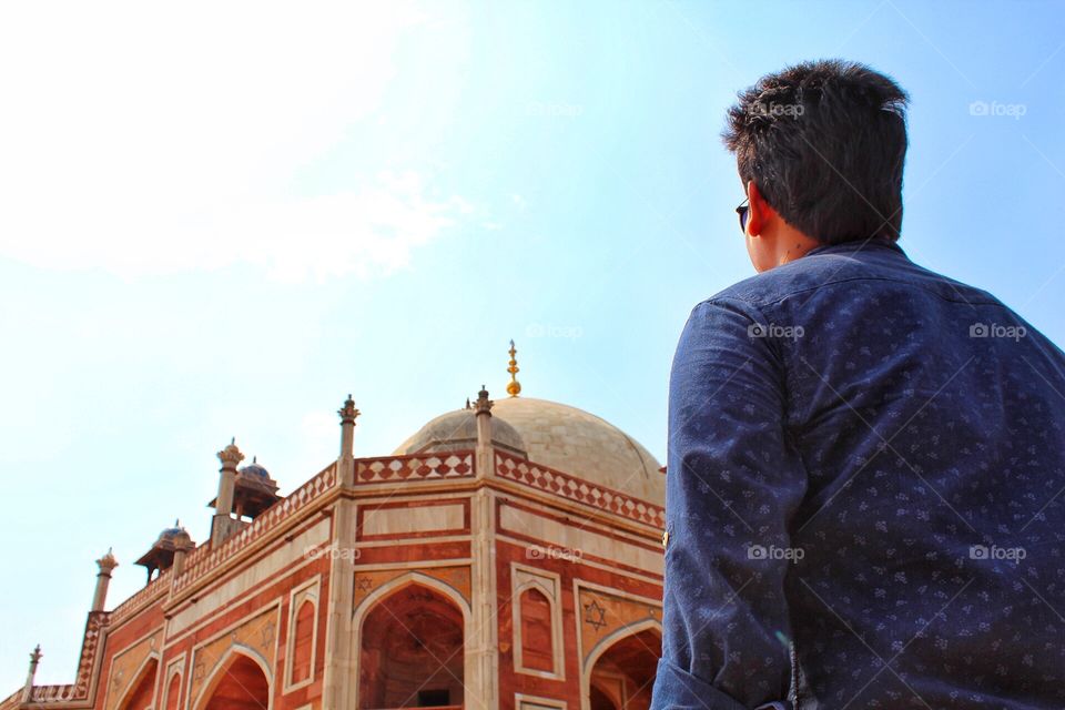 A man majestically looking at the architectural beauty, Humayun’s Tomb. This tomb is situated in the hustle bustle of capital city of India, New Delhi. 