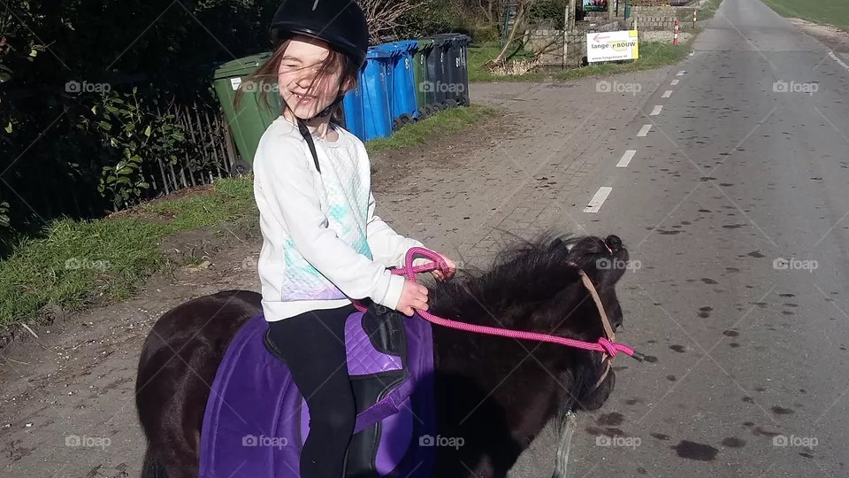 Girl riding a shetlander outside