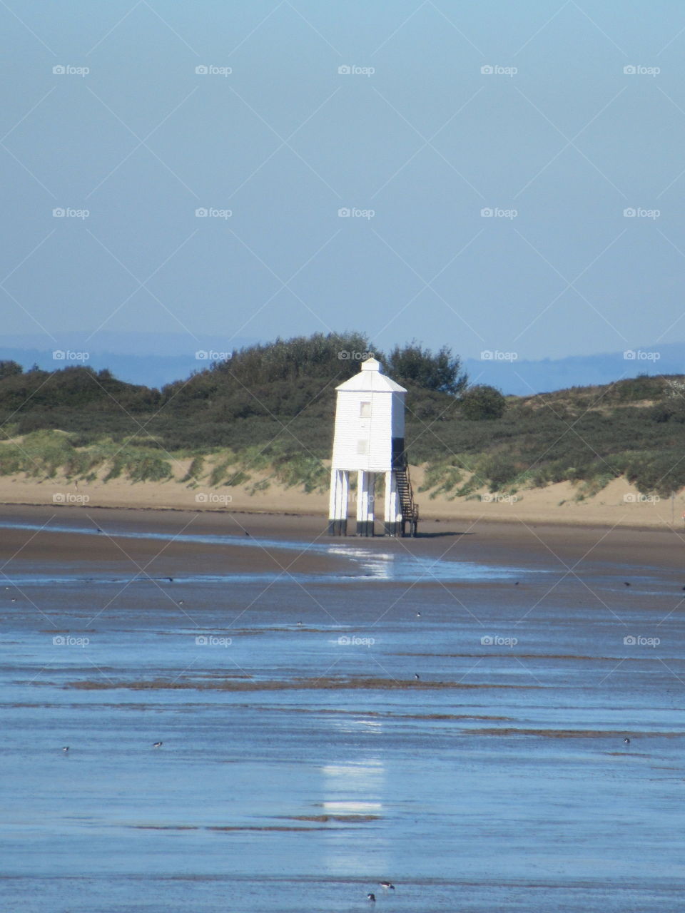 lighthouse reflection on the beach where the tide was