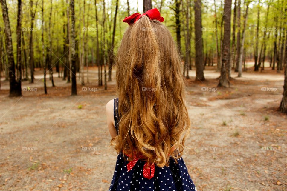 Young girl looking out into the woods 