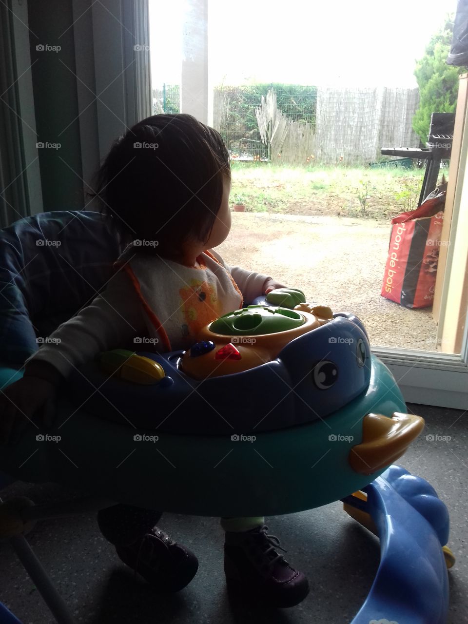 riding her walker while watching outside