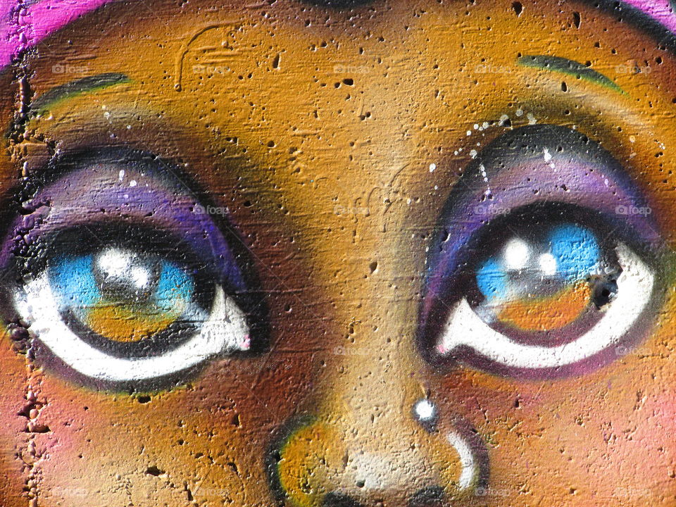 brown and blue eyed wall painting of a face. In an Alleyway in downtown Sacramento
