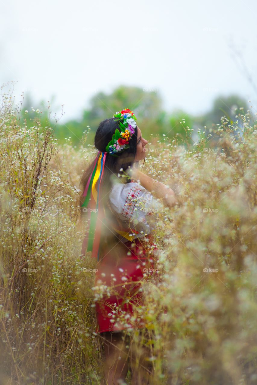 Side view of woman standing in flower field