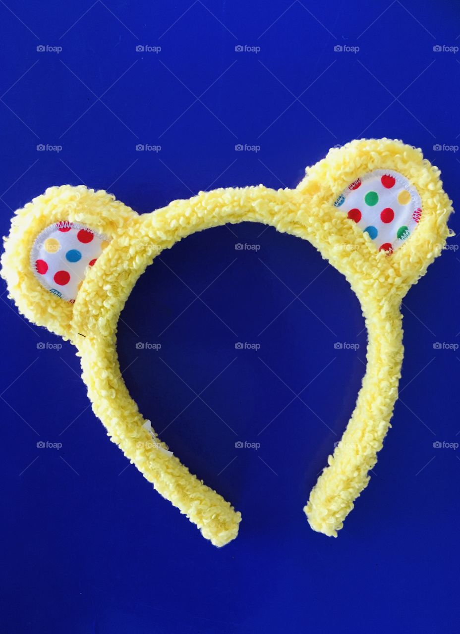 Bright yellow Pudsey ears set against bold background. Clean flat lay look. Children in need. Charity. 