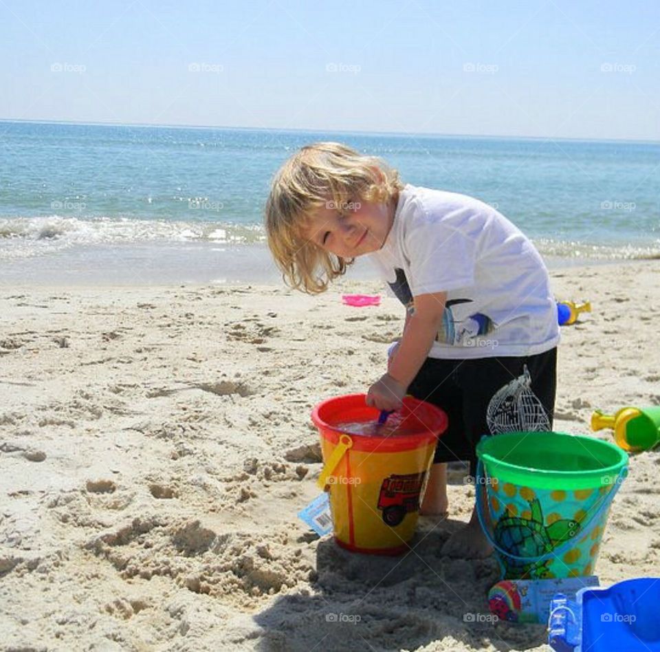 Small little boy plating at beach