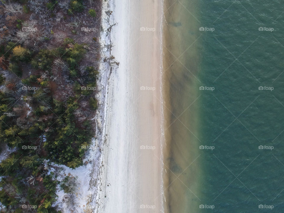 Beach view from above, shoreline up against the sand.