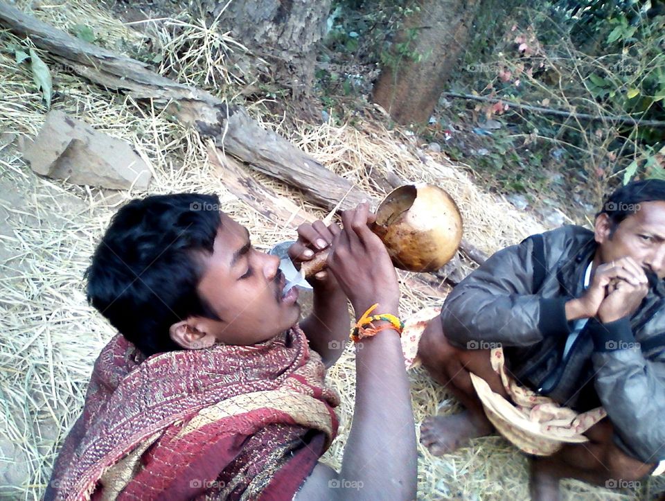 A  INDIAN tribal boy having natural alcohol , called Jeelugu kallu.