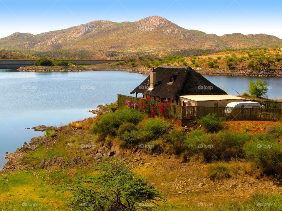 Lake Oanob view with mountains, house and acacia trees in Central Namibia 