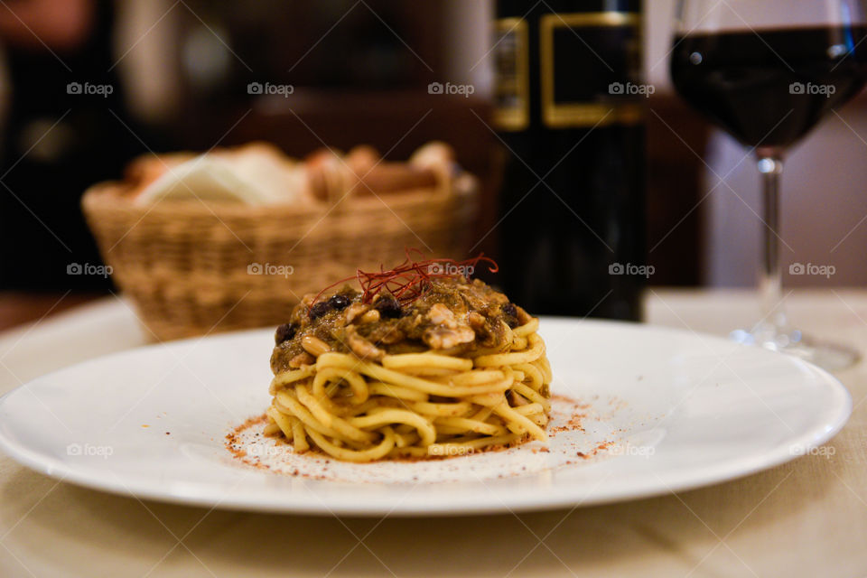 Pasta dish at the restaurant in Sicily with red wine and bread.