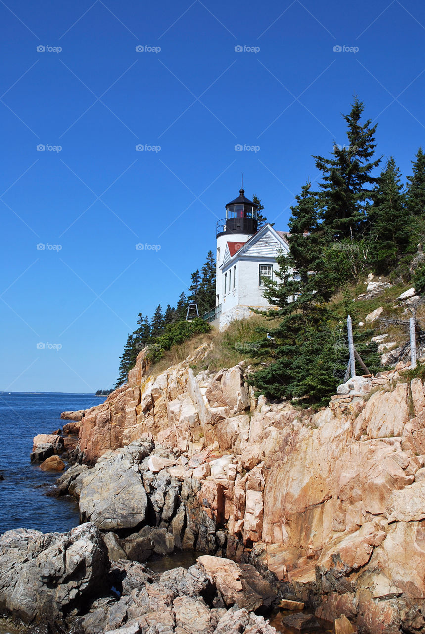 The contrast of the blue sky and water against the rocks and light house are perfect.  Bass Harbor Light,  Bass Harbor Acadia National Park 