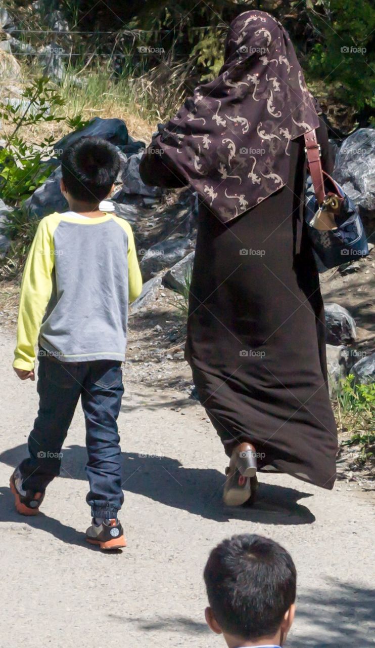 Muslim woman walking with son