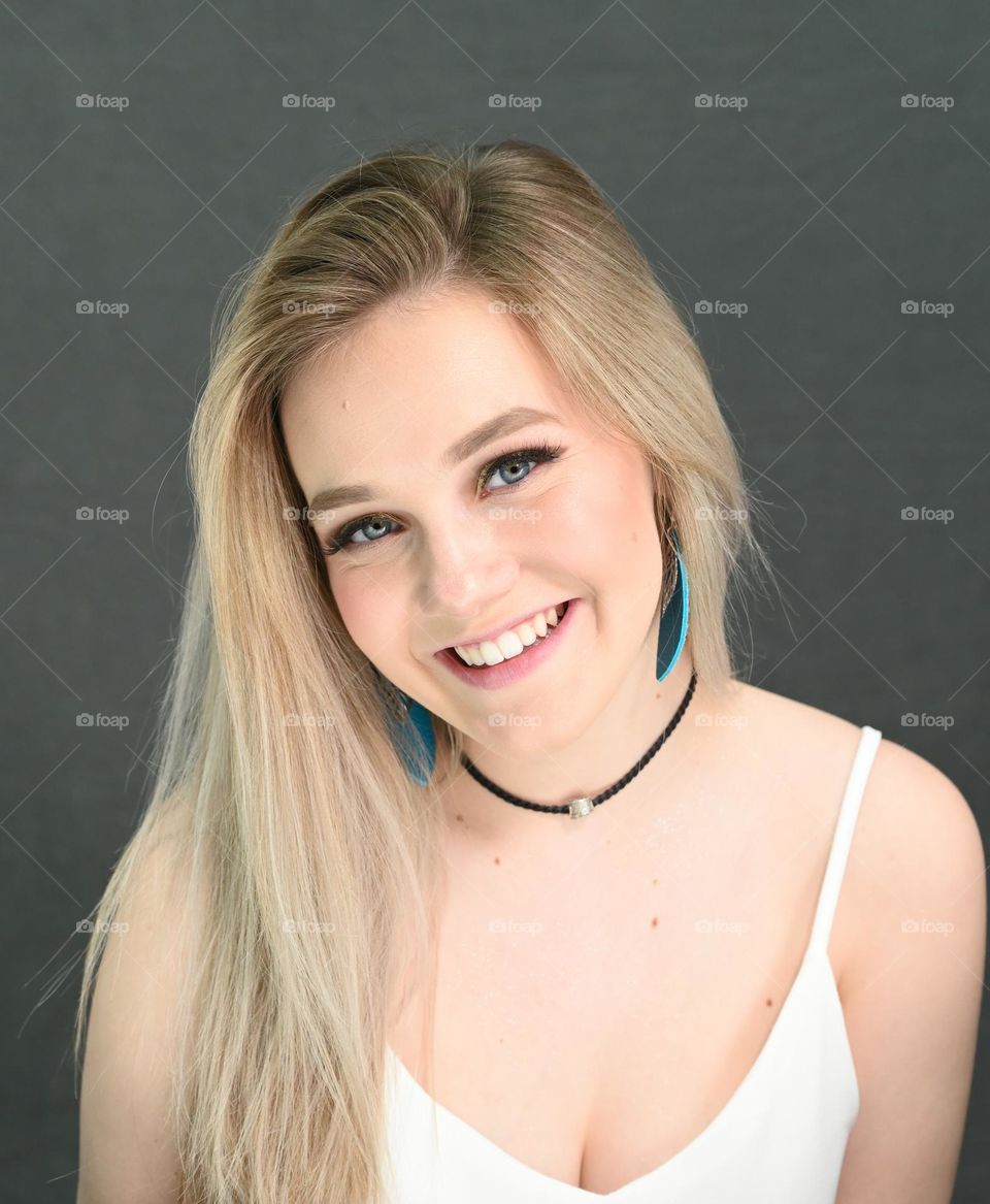 Pretty young woman, self-confident smiling studio portrait