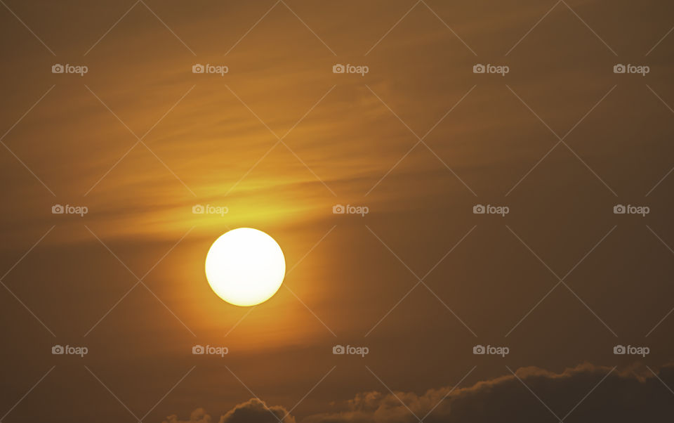 The golden light of the sun and clouds in the sky.