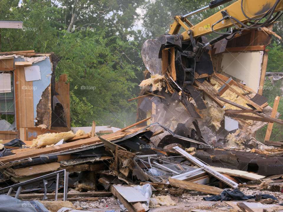 Clearing Away the Wreckage. An Excavator Completes Demolition Prior to Rebuilding a Storm Damaged Home.