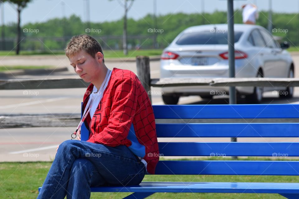 Teenager on a park bench. Thinking 