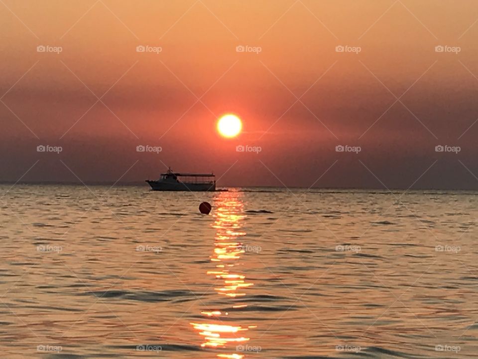 Sunset with boat on the Mediterranean Sea in Greece 