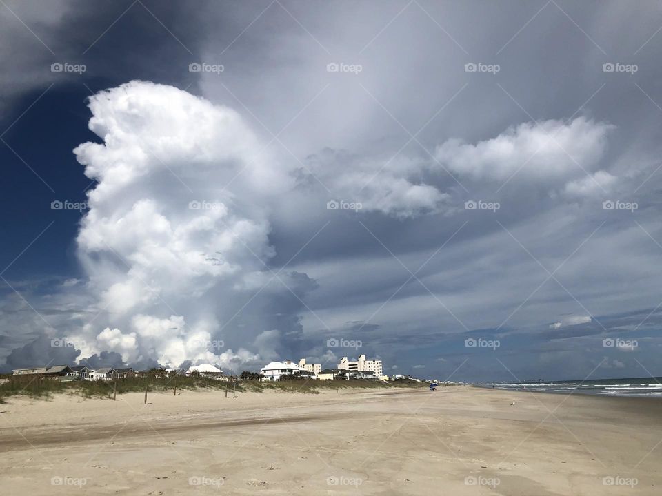Off the Atlantic Coast line near Emerald Isles, North Carolina Huge Fluffy Clouds hand from darkening sky. 