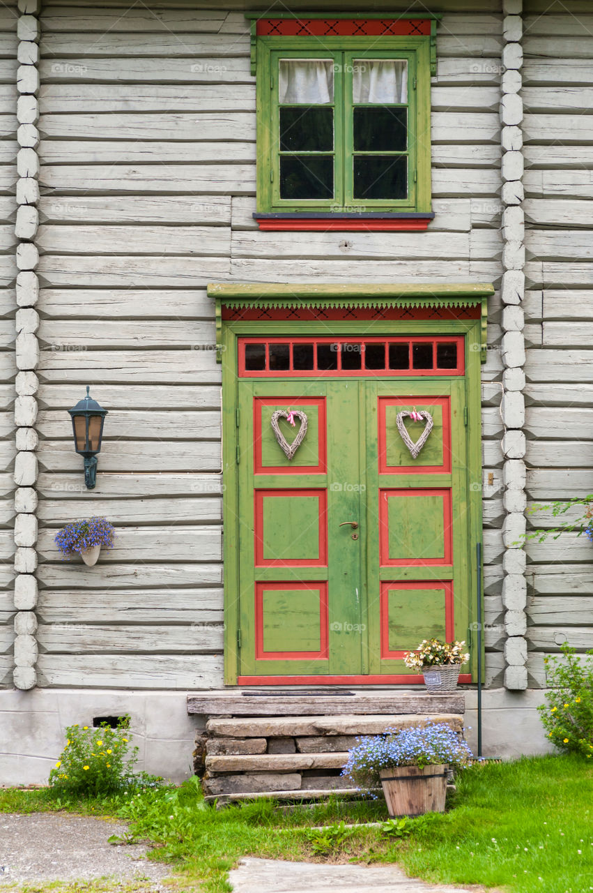 Decorative wooden green door in a wooden trunk house.