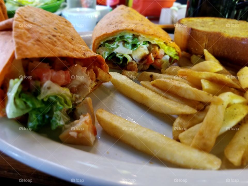 bbq chicken wrap with garlic bread and fries