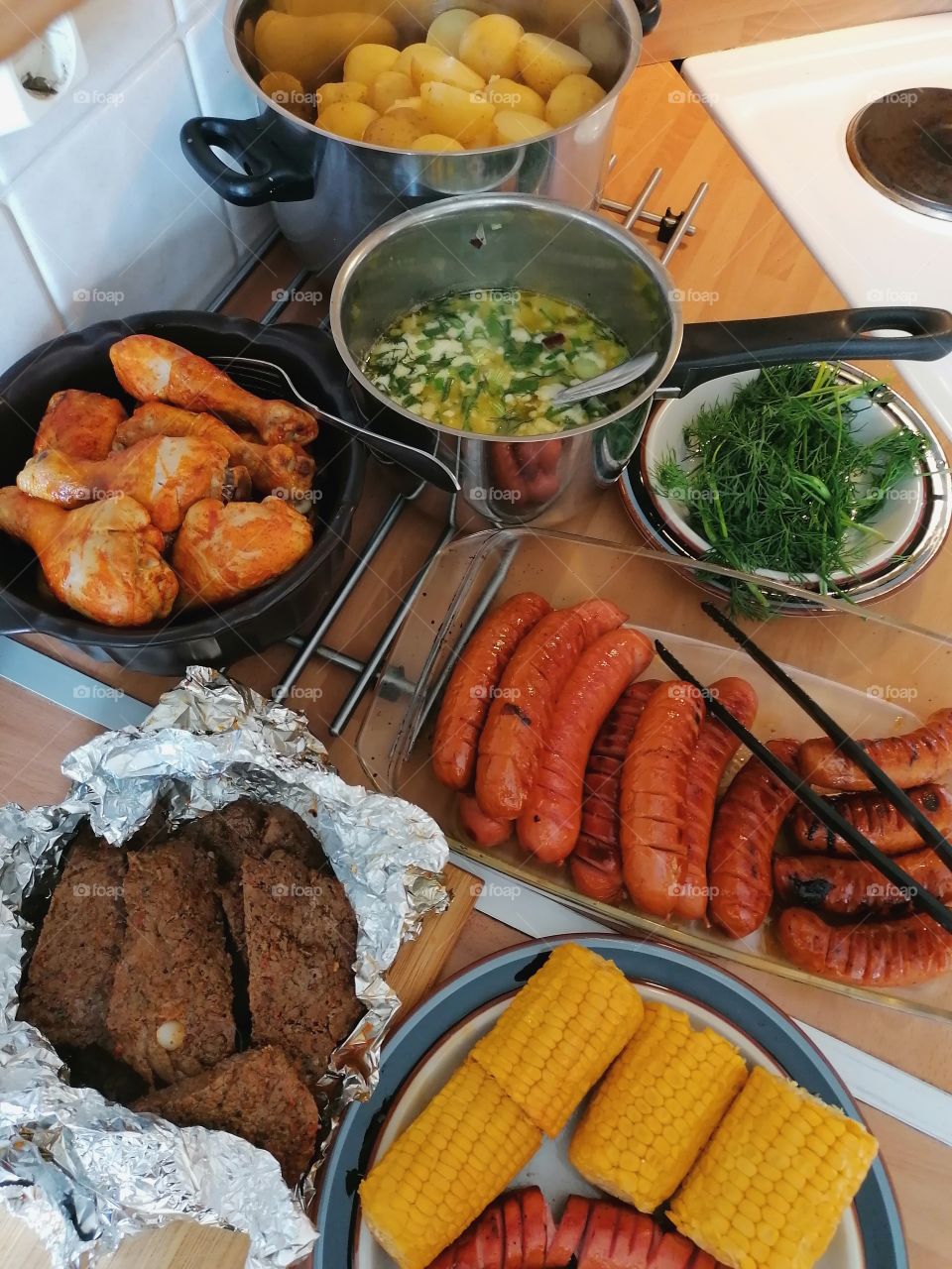 Traditional Finnish summer food. Boiled potatoes, dill butter onion sauce, various sausages, steak, salad, chicken and grilled corn. Really good!