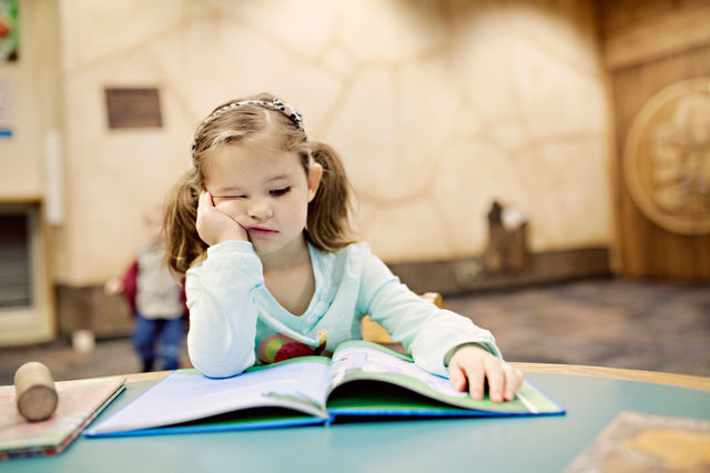 Little girl at the library looking bored 