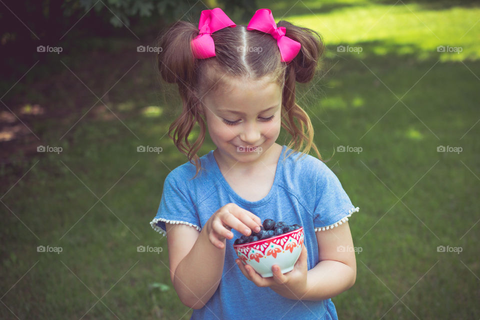 Young Girl with Pink Hairbows Eating Blueberries 23