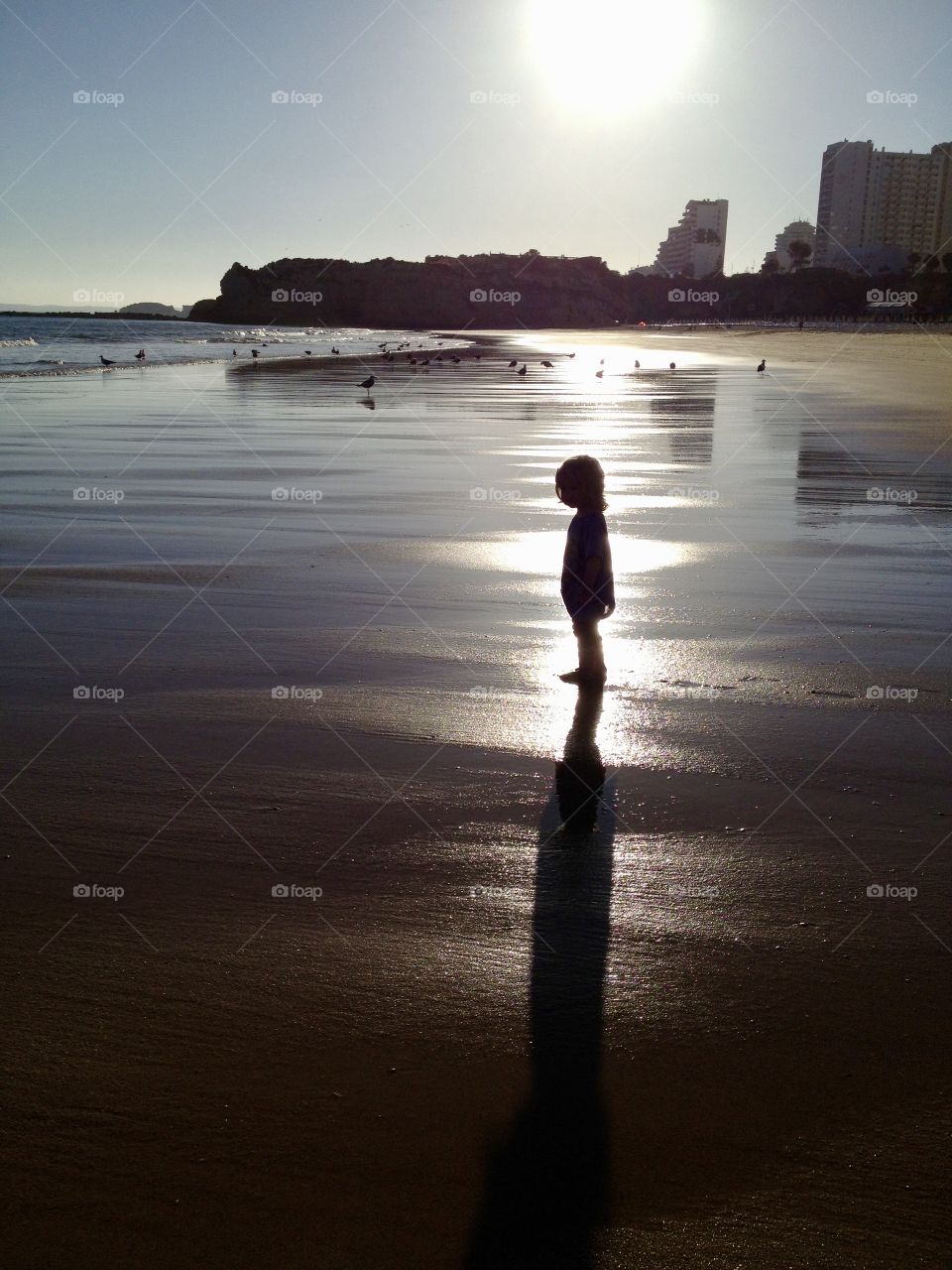 Child enjoying the last rays of sunshine for the day at Praia da Rocha, Portugal