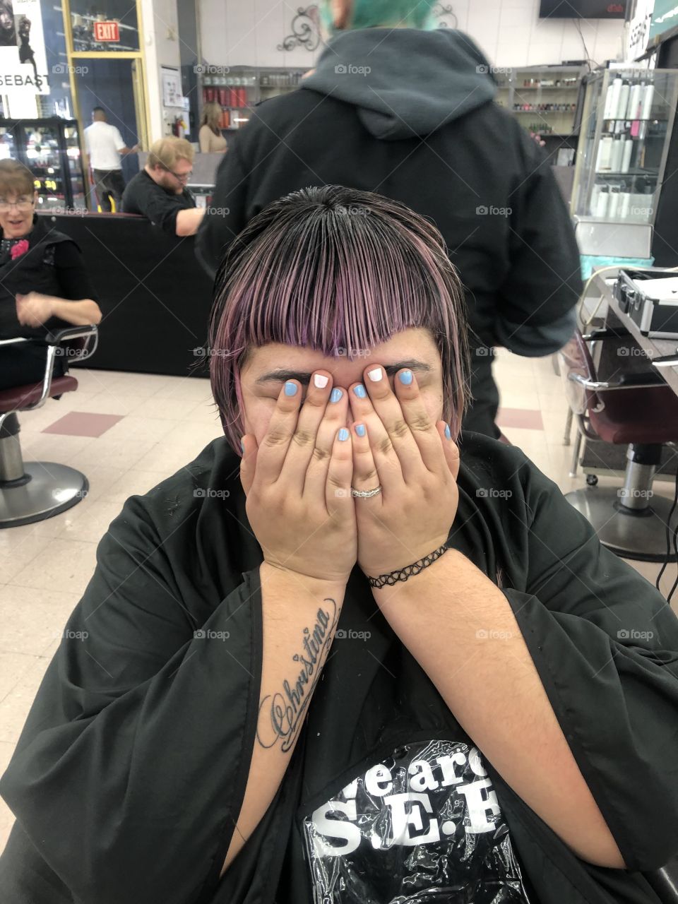 Girl covers her eyes before seeing her new haircut for the first time.