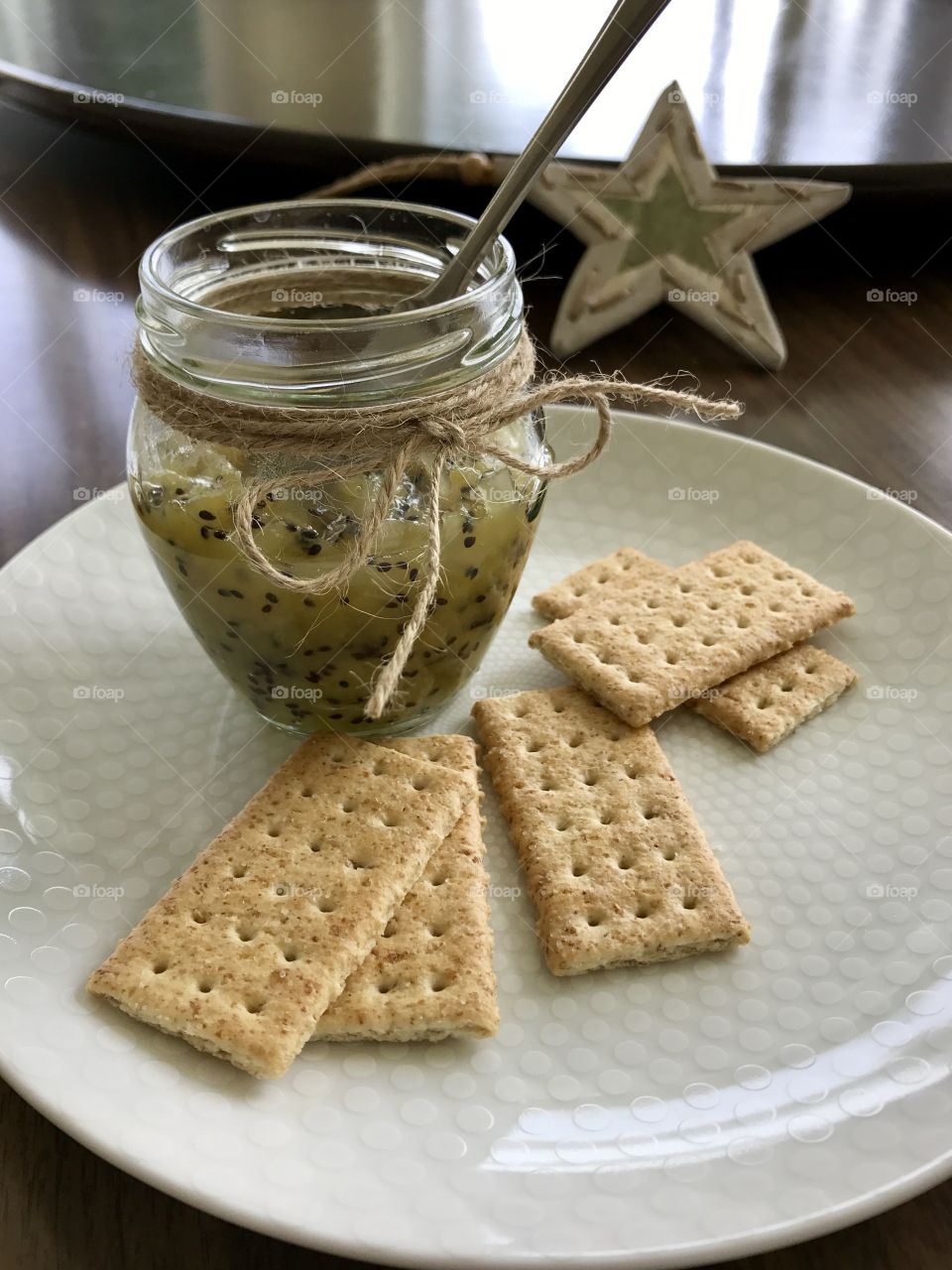 Homemade Kiwi jam and crackers on a plate 