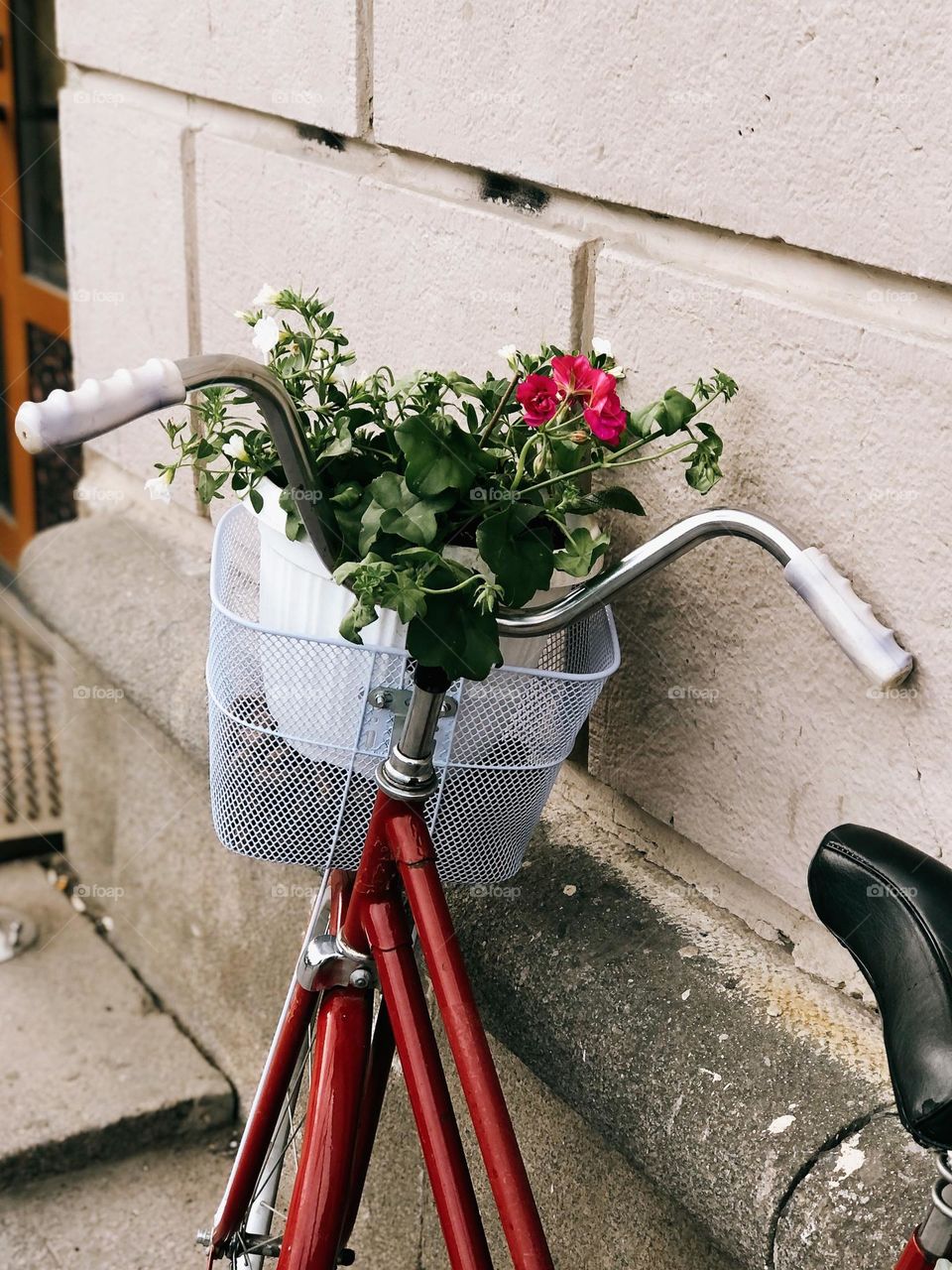 Lonely red bicycle with flowers on the street 