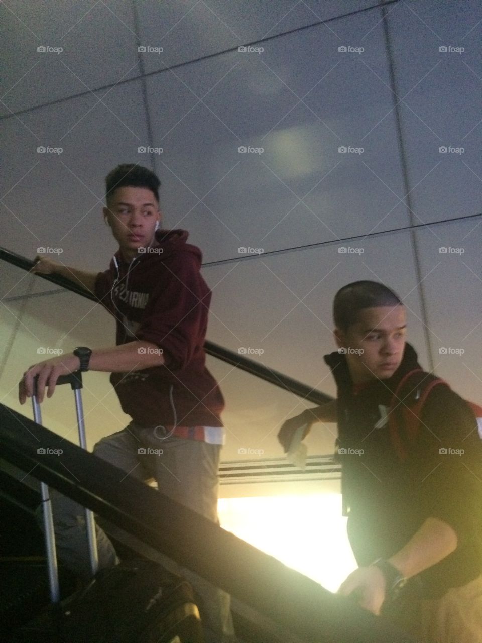 Two young man standing on escalator