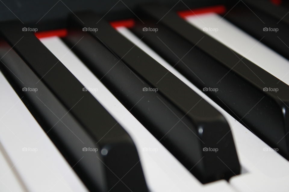 Red soft cloth brushing along digital piano keys 