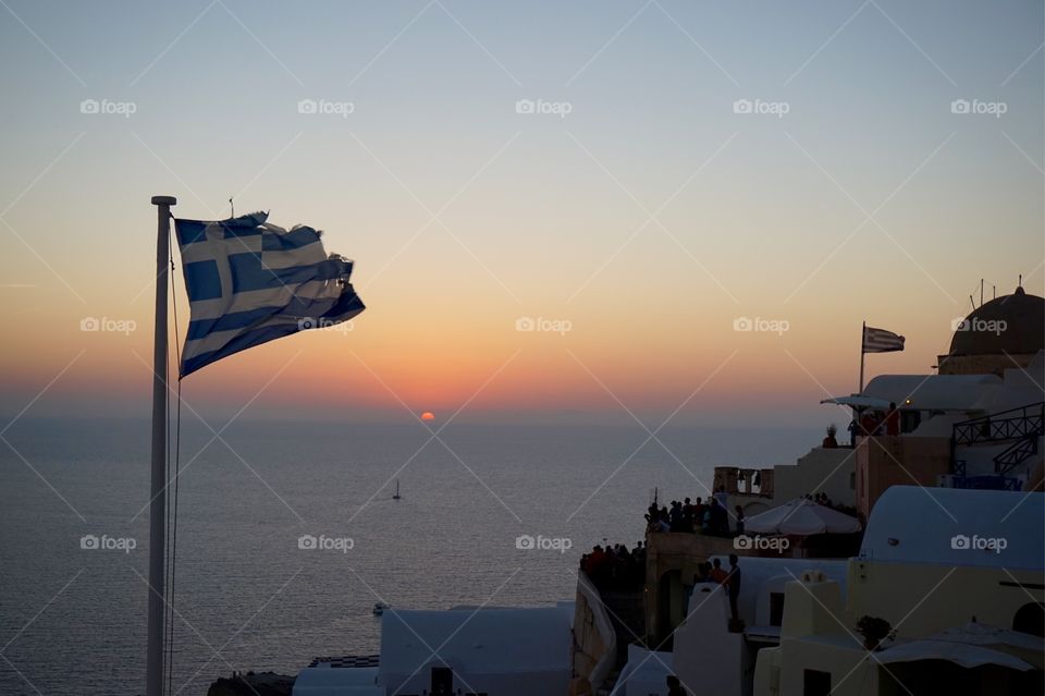 Greek flag at sunset in Oia, Santorini, Greece 