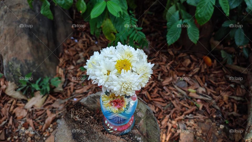 Beautiful white flowers in a colourful flowerpot with a flower sculpture, Flowers in a vase, colourful vase, white flowers in a vase