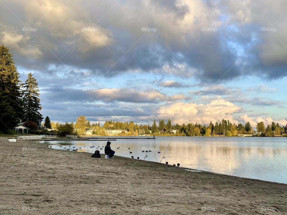 Lonely fisherman on the bank of the lake