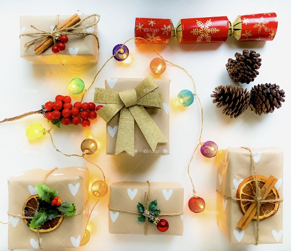 Brown paper packages tied up with string and natural themed decorations, with coloured lights