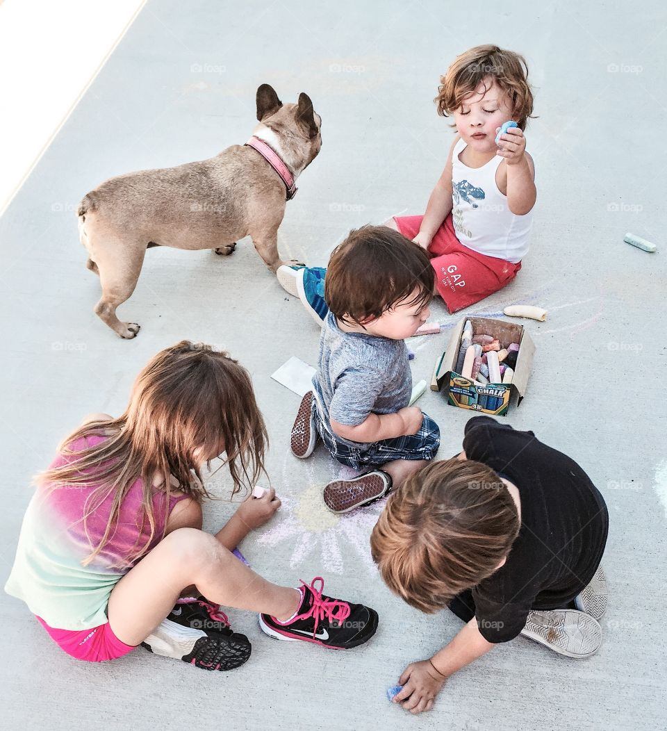 Children drawing with chalk on concrete flowing